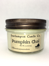 Load image into Gallery viewer, A creamy off-white natural soy and coconut wax candle in a glass mason jar. It has a bronze lid and a kraft paper label that reads 'Southampton Candle Company' and 'Pumpkin Chai'. Its net weight is 2.3 ounces.