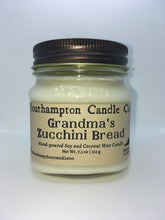 Load image into Gallery viewer, A creamy off-white natural soy and coconut wax candle in a glass mason jar. It has a bronze lid and a kraft paper label that reads 'Southampton Candle Company' and 'Grandma's Zucchini Bread.'.