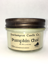 Load image into Gallery viewer, A creamy off-white natural soy and coconut wax candle in a glass mason jar. It has a bronze lid and a kraft paper label that reads &#39;Southampton Candle Company&#39; and &#39;Pumpkin Chai&#39;. Its net weight is 2.3 ounces.
