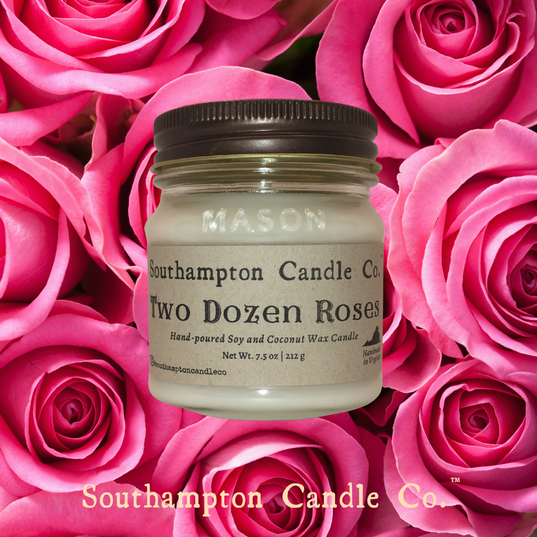Up close photo of 8 ounce candle in 'Two Dozen Roses (TM)' candle by Southampton Candle Company, with pink rose backgrond.